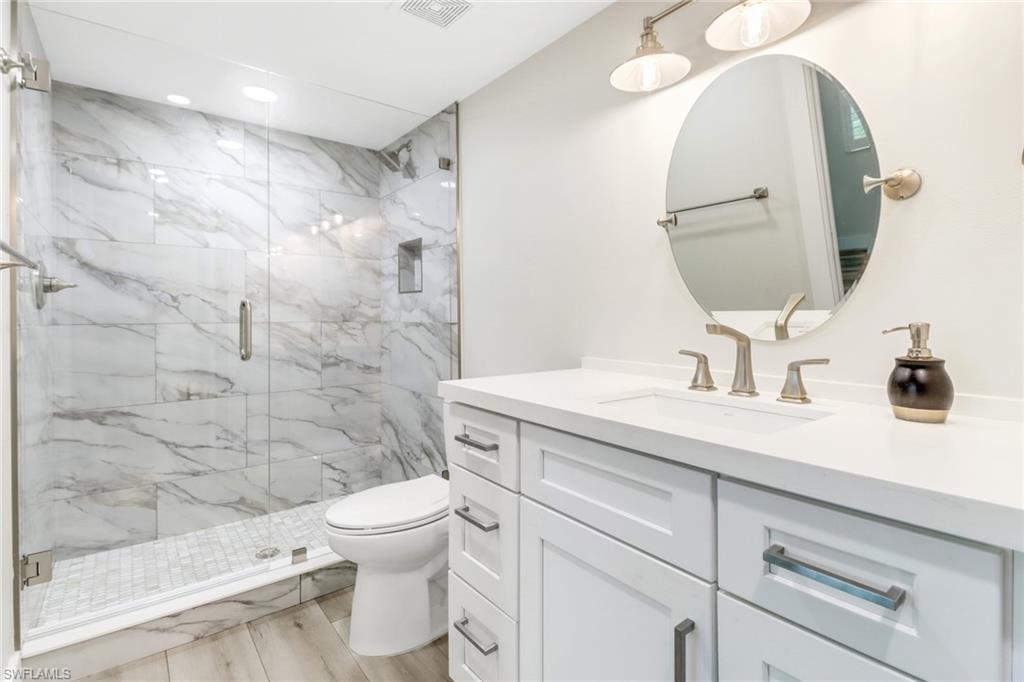 1549 Sandpiper Street, Unit 1 Naples, FL 34102 - Photo 9 of 16 a bathroom with a sink a toilet and shower