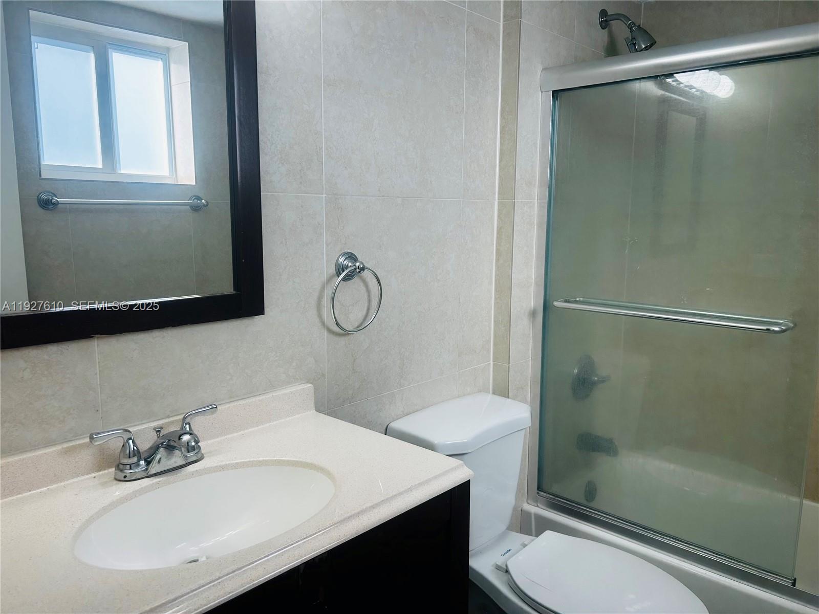 1665 Bay Road, Unit 415 Miami Beach, FL 33139 - Photo 5 of 7 a bathroom with a sink toilet and shower