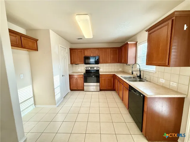 a large kitchen with cabinets and stainless steel appliances