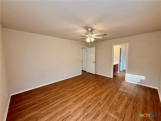 a view of an empty room with wooden floor