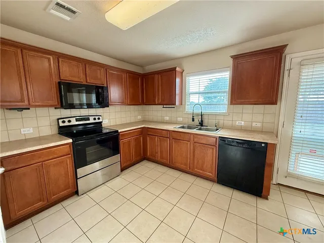 a kitchen with a sink stove and microwave