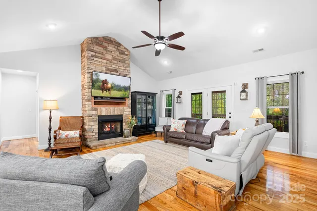 a living room with furniture a fireplace and a floor to ceiling window