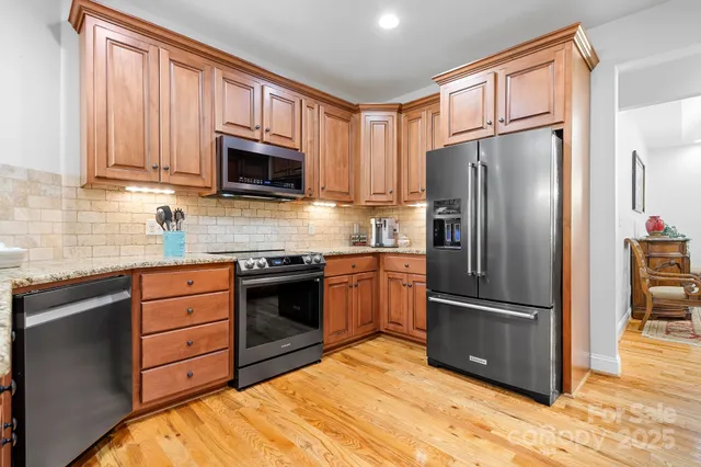 a kitchen with granite countertop stainless steel appliances and wooden cabinets