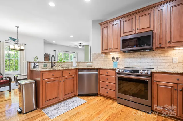 a kitchen with stainless steel appliances granite countertop a stove top oven a sink dishwasher and a microwave oven on the blue kitchen countertops