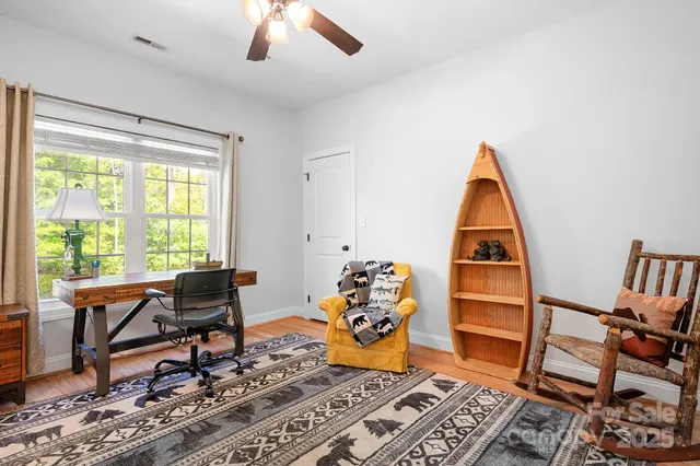 a view of a workspace with furniture and a window