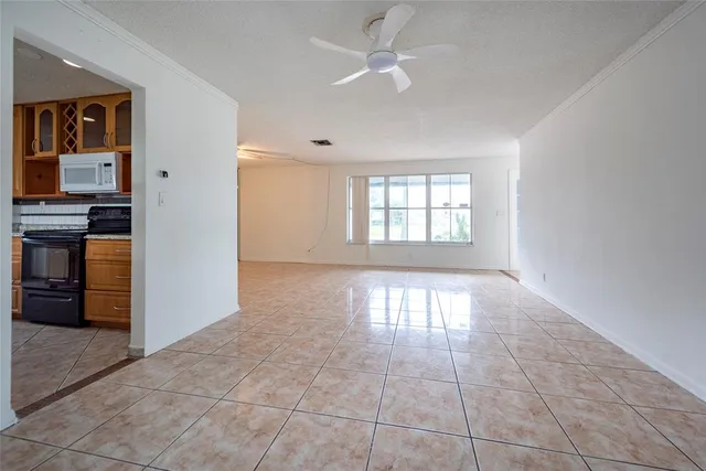 an empty room with windows and ceiling fan