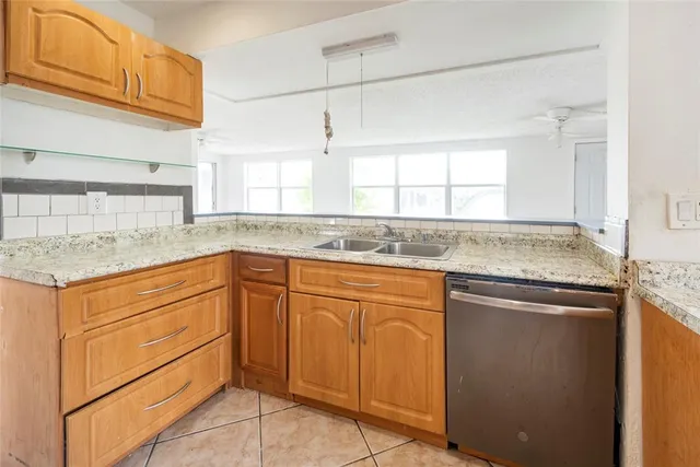 a kitchen with granite countertop cabinets sink and window