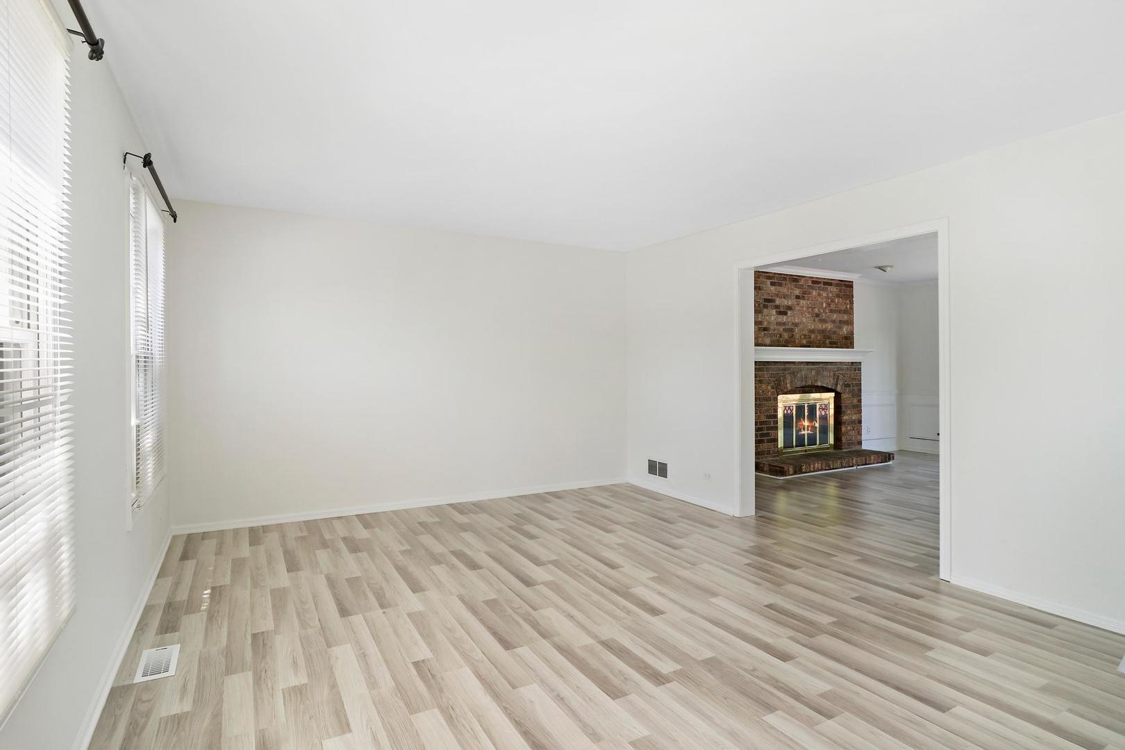 149 West Schick Road Bloomingdale, IL 60108 - Photo 3 of 35 an empty room with wooden floor and a window