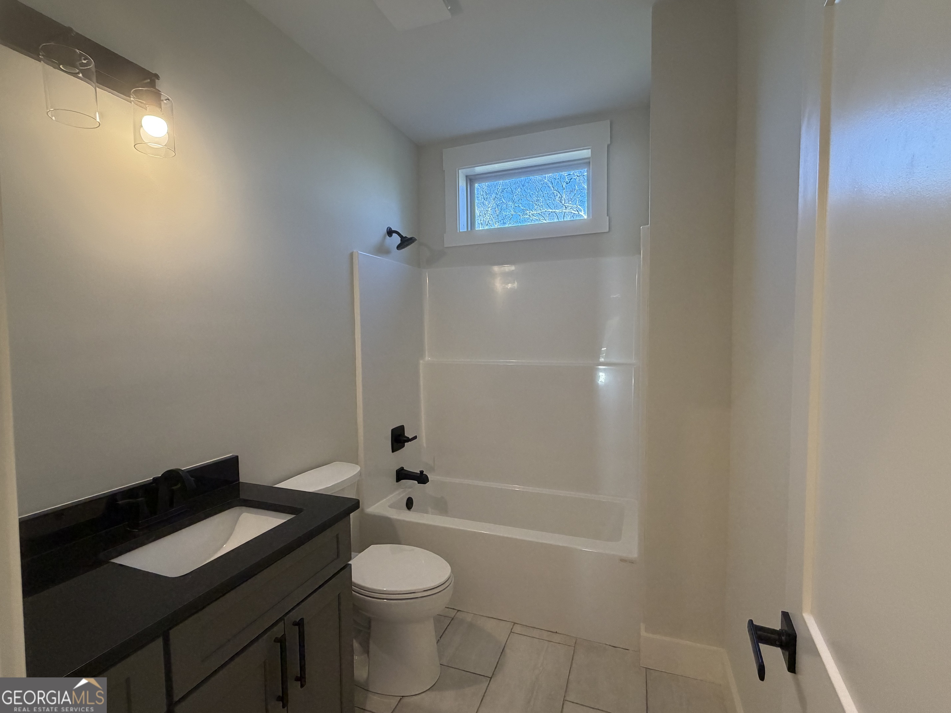 438 Mill Ridge Road Hiawassee, GA 30546 - Photo 23 of 75 a bathroom with a granite countertop toilet a sink and bathtub