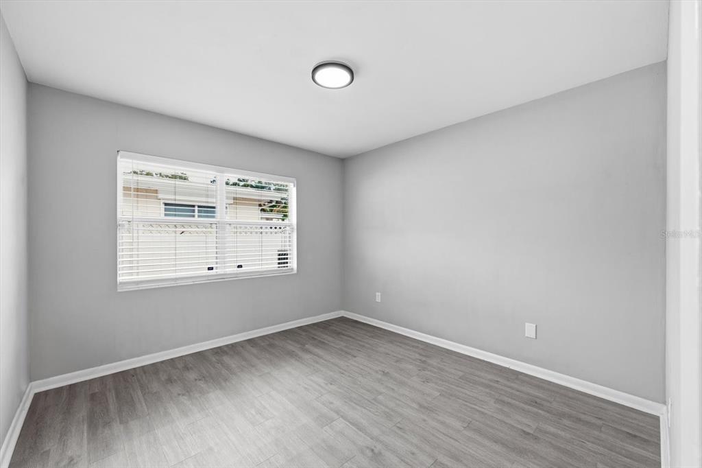 1439 Wilson Road Clearwater, FL 33755 - Photo 13 of 26 an empty room with wooden floor and windows