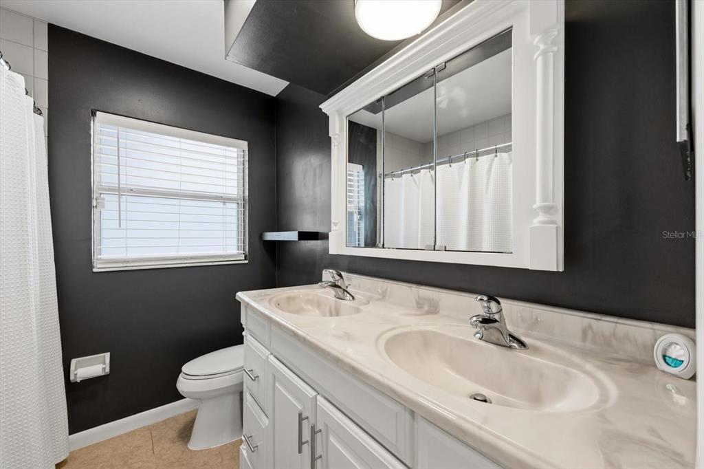 1439 Wilson Road Clearwater, FL 33755 - Photo 15 of 26 a bathroom with a sink toilet and mirror
