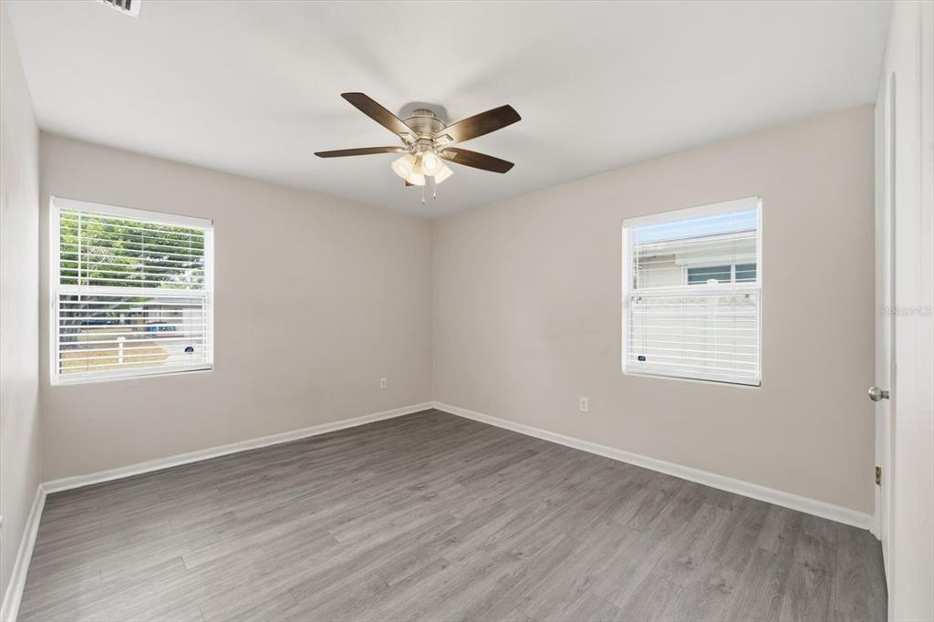 1439 Wilson Road Clearwater, FL 33755 - Photo 16 of 26 a view of an empty room with wooden floor and a window