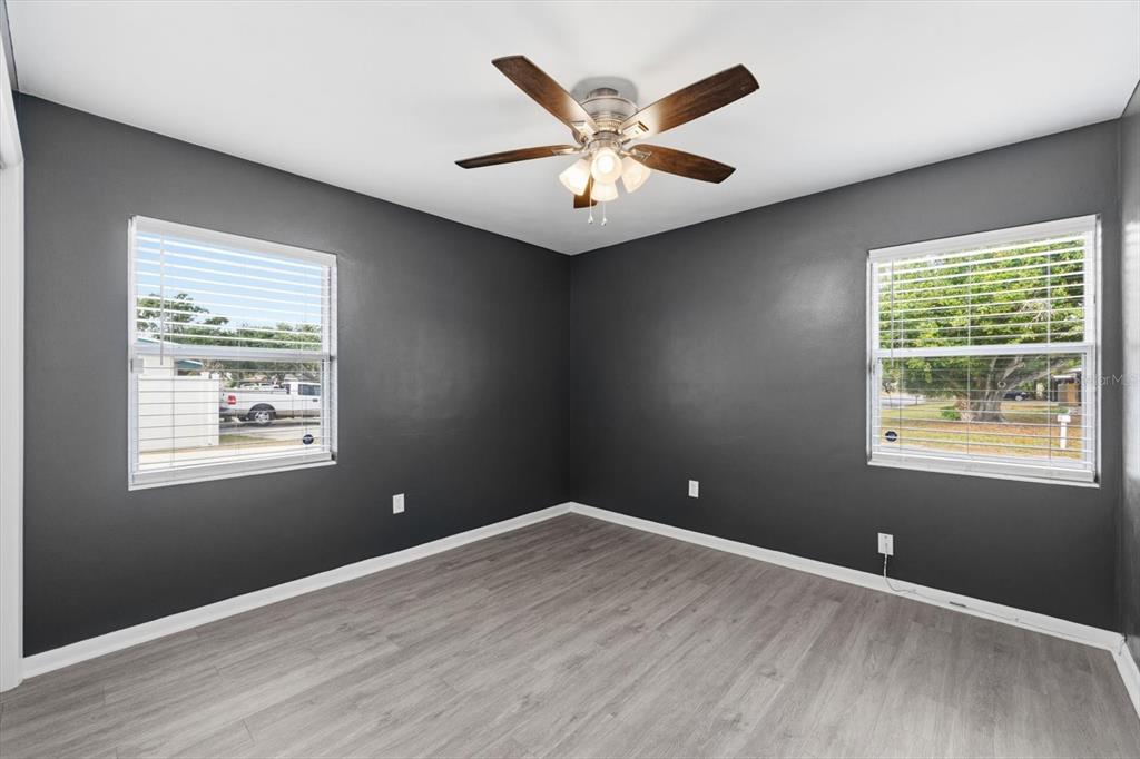 1439 Wilson Road Clearwater, FL 33755 - Photo 18 of 26 an empty room with wooden floor and windows