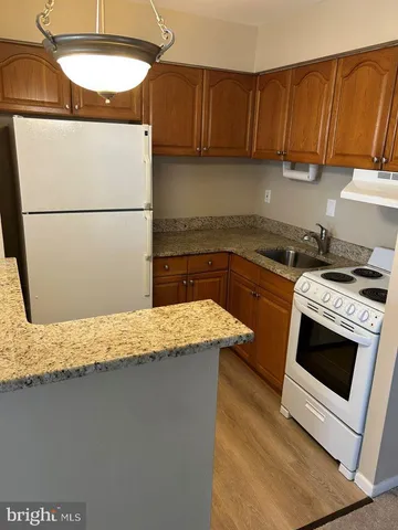a kitchen with granite countertop a sink a stove and a refrigerator