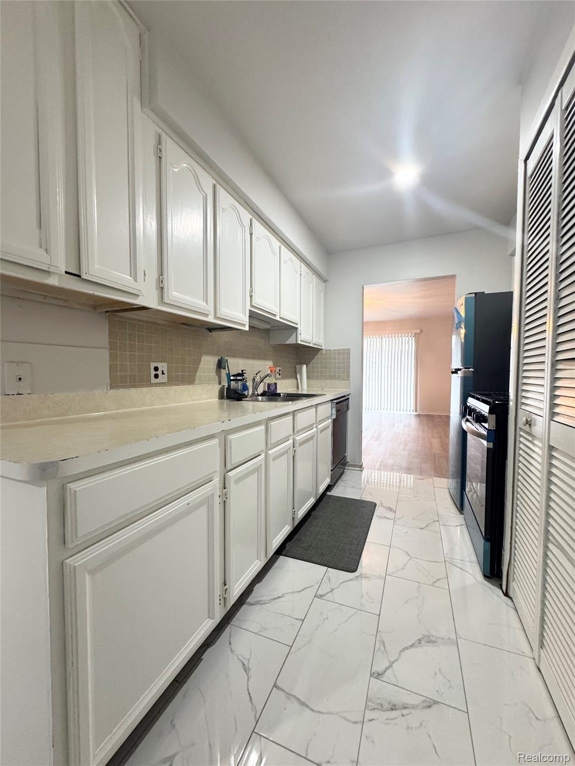4386 15 Mile Road, Unit 64 Sterling Heights, MI 48310 - Photo 10 of 23 Galley kitchen with white cabinetry and a light-colored countertop