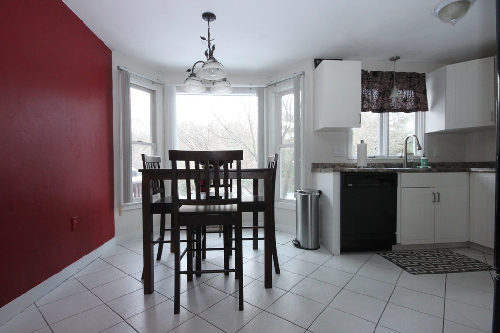 1 Country Side Road, Unit 1 Bellingham, MA 02019 - Photo 6 of 20 a kitchen with a dining table chairs and refrigerator