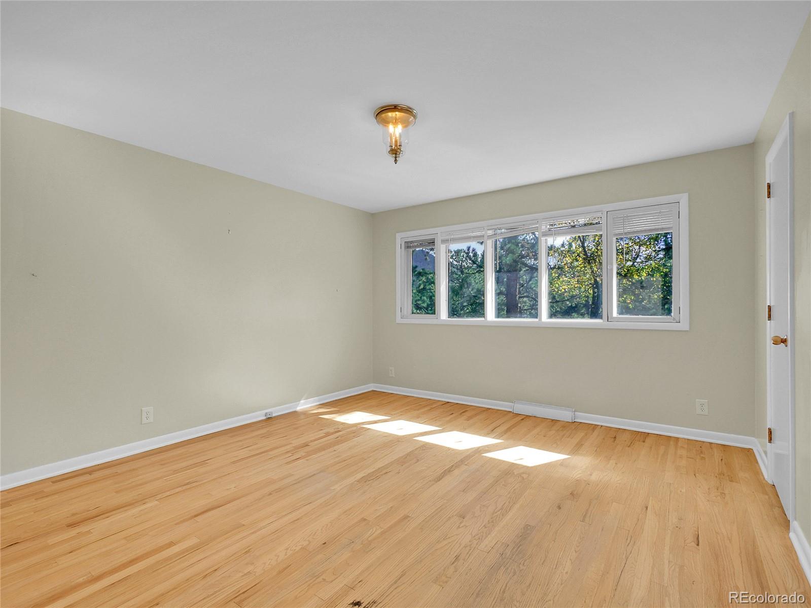 28449 Douglas Park Road Evergreen, CO 80439 - Photo 20 of 25 a view of an empty room with wooden floor and a window