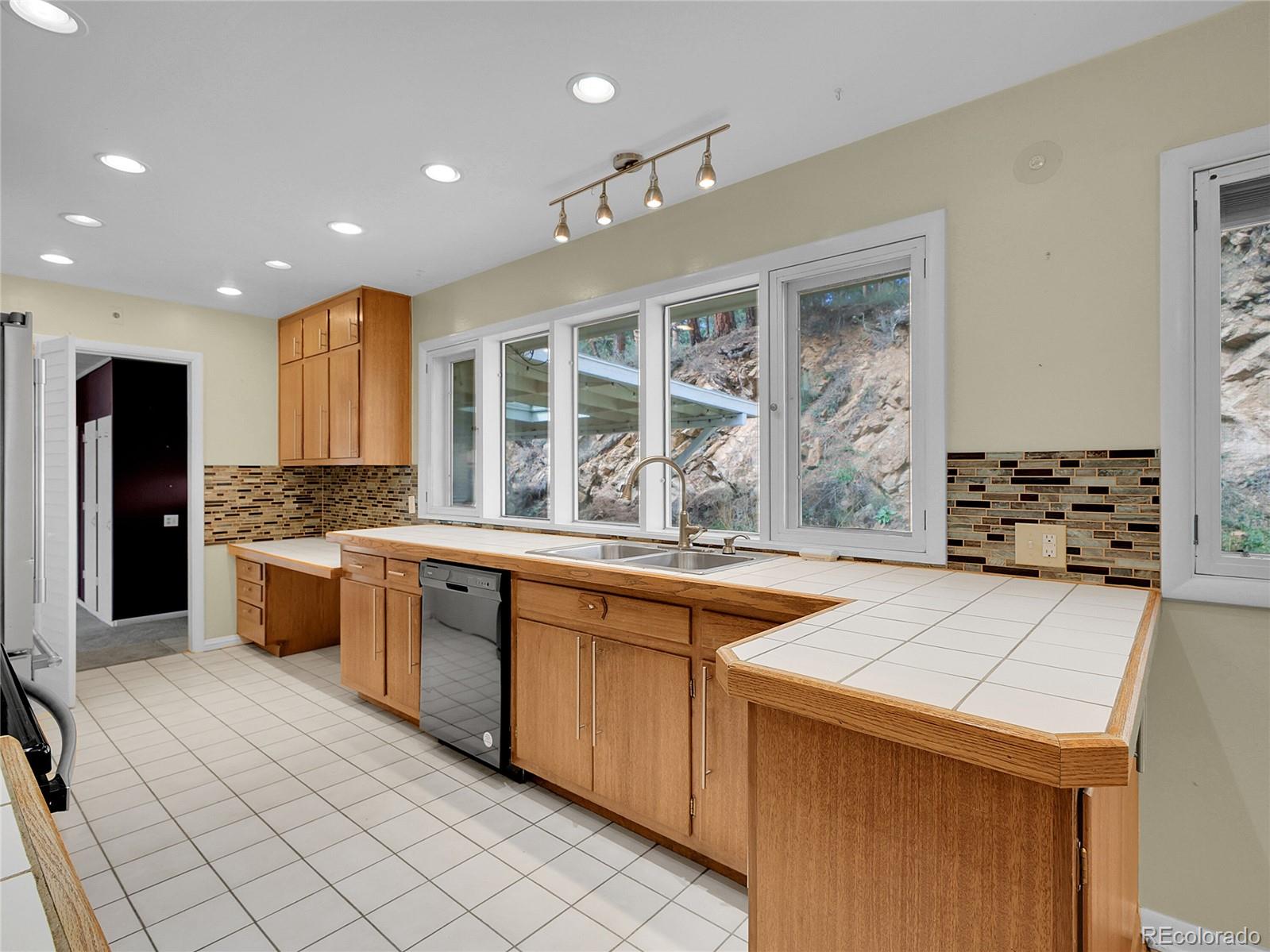 28449 Douglas Park Road Evergreen, CO 80439 - Photo 6 of 25 a large kitchen with kitchen island a sink stainless steel appliances and cabinets