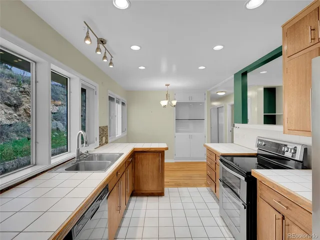 a kitchen with stainless steel appliances granite countertop a sink and a stove