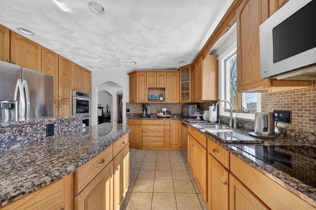 155 Sagamore Road Seekonk, MA 02771 - Photo 11 of 41 a large kitchen with stainless steel appliances granite countertop a stove a sink and a microwave