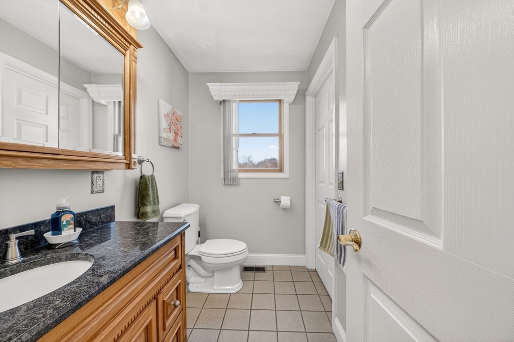 155 Sagamore Road Seekonk, MA 02771 - Photo 17 of 41 a bathroom with a granite countertop sink a toilet and a mirror