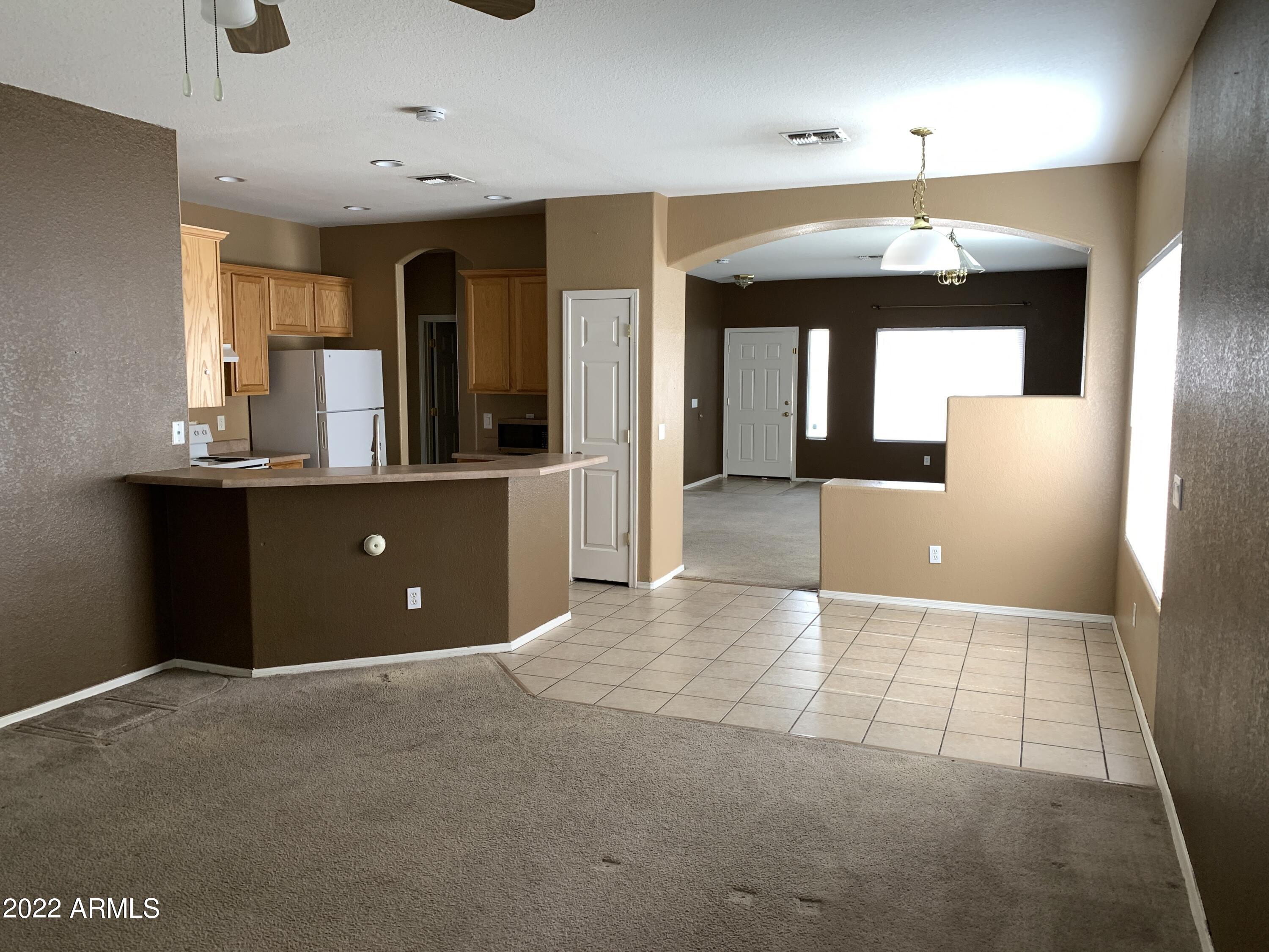 810 South 124th Avenue Avondale, AZ 85323 - Photo 5 of 18 an open kitchen with a sink and chandelier