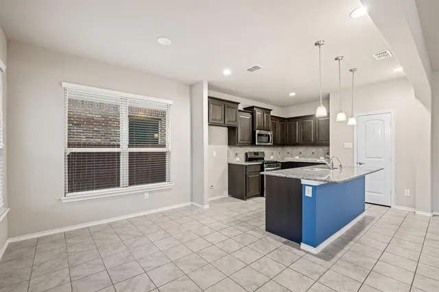 a kitchen with stainless steel appliances granite countertop a sink stove and cabinets