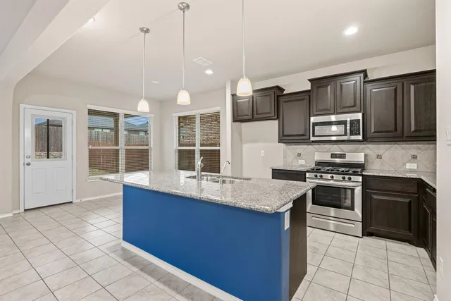 a kitchen with granite countertop a stove and a sink