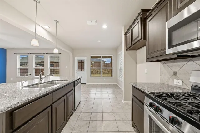 a kitchen with a sink a stove and cabinets