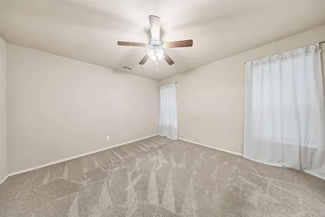 a view of an empty room and a ceiling fan