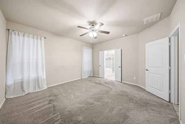 an empty room with closet and fan