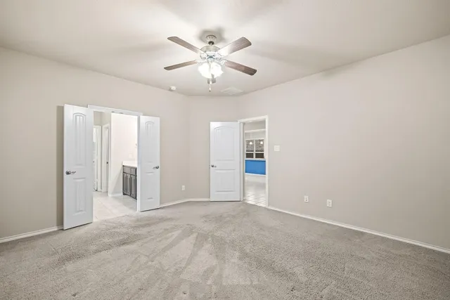 an empty room with fan and a ceiling fan