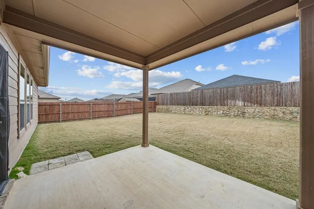 a view of backyard with wooden fence