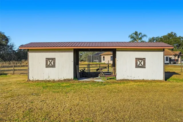 a view of a house with a yard and a large tree