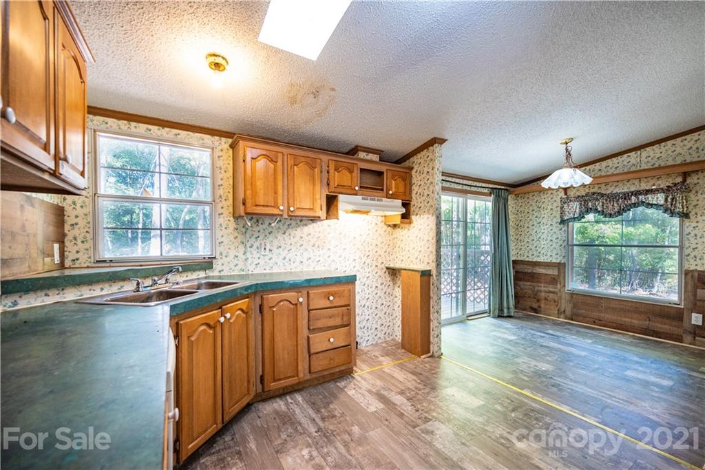 6550 Lewis Road Kings Mountain, NC 28086 - Photo 9 of 20 a kitchen with stainless steel appliances granite countertop a sink and wooden cabinets with a large window