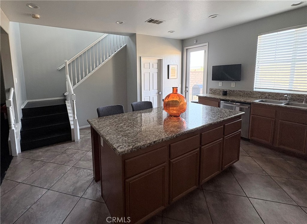 2729 Hornbeam Road Palmdale, CA 93551 - Photo 8 of 35 a kitchen with a granite countertop sink and cabinets