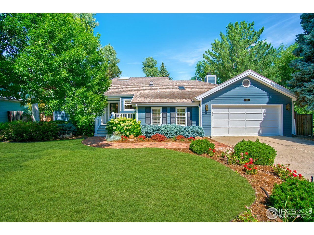 a front view of a house with a yard and trees