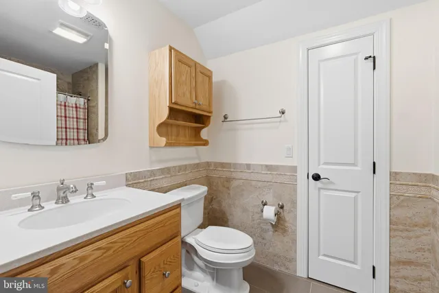 a bathroom with a granite countertop toilet sink and mirror