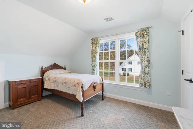 a spacious bedroom with a bed and a window