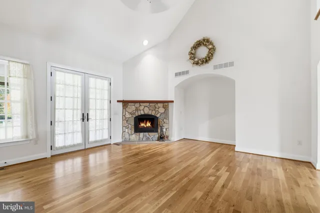 a view of empty room with wooden floor and fireplace