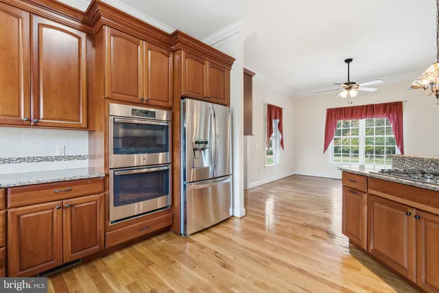 a kitchen with stainless steel appliances granite countertop a refrigerator stove and sink