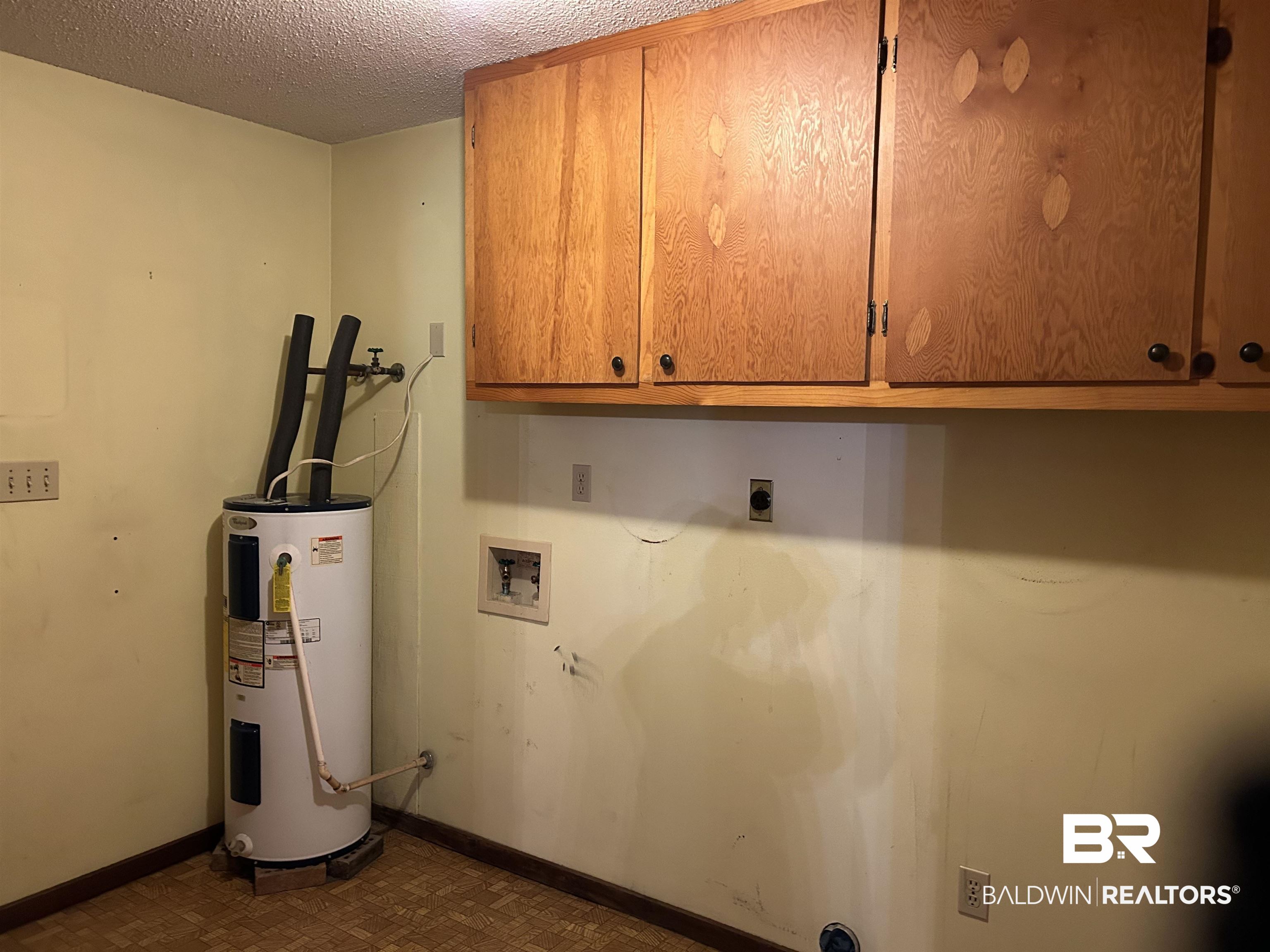 1350 A Schillinger Road South Mobile, AL 36695 - Photo 4 of 18 Washroom featuring electric water heater, cabinet space, washer hookup, hookup for an electric dryer, and a textured ceiling