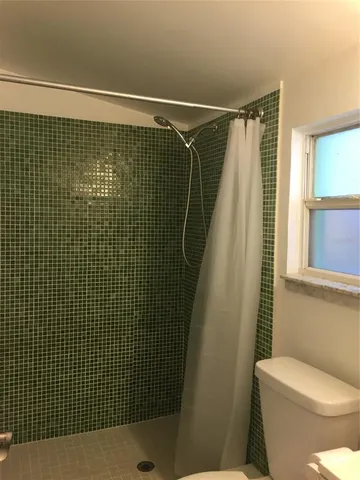 a bathroom with a shower toilet and sink