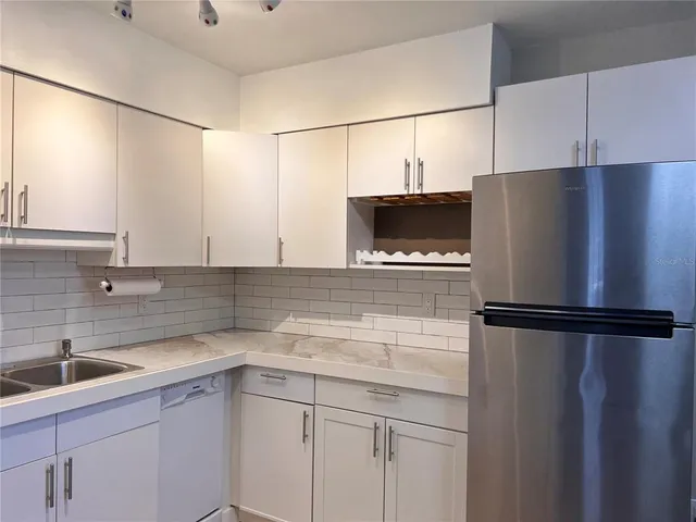 a kitchen with a refrigerator and a sink