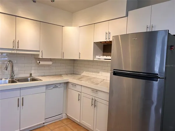 a kitchen with a refrigerator and a sink