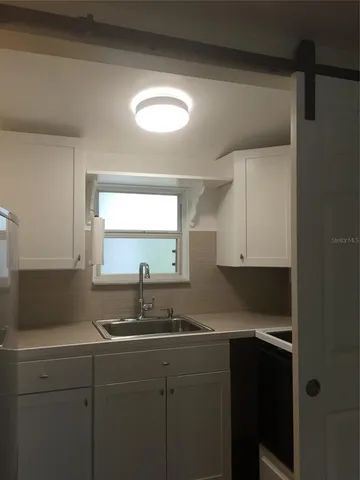 a kitchen with a sink cabinets and window