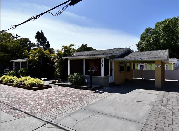 a front view of a house with a yard and potted plants