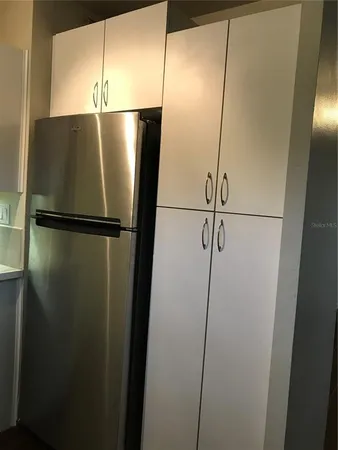 a view of a refrigerator in kitchen and a wooden floor