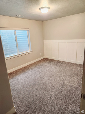 36 West Syracuse Road Vineyard, UT 84059 - Photo 54 of 56 Carpeted room featuring a window with blinds, baseboard trim, and wainscoting