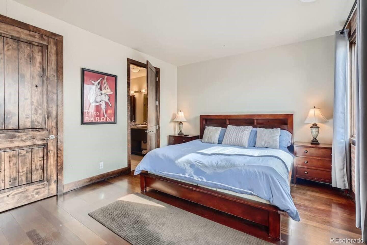 2101 Larimer Street, Unit 303 Denver, CO 80205 - Photo 11 of 21 a bedroom with a bed and wooden floor